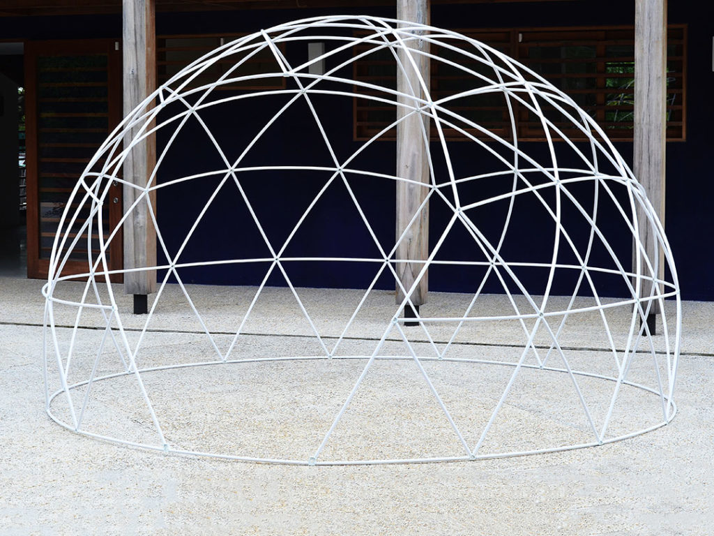 Geodesic Dome with a sturdy metal frame standing outdoors on gravel in front of wooden columns