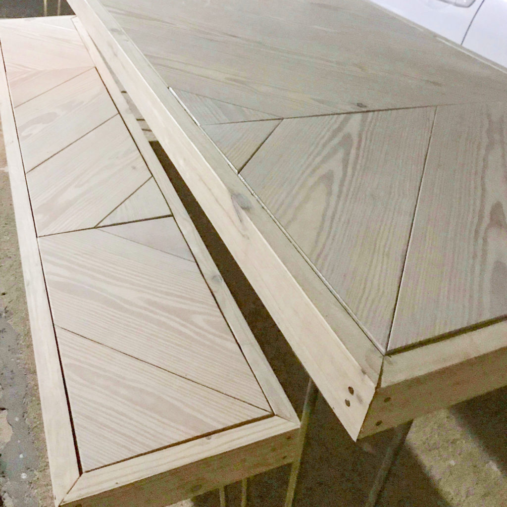 Hairpin Sweetheart Table, two unfinished tables with geometric chevron-patterned tops side by side on a concrete floor