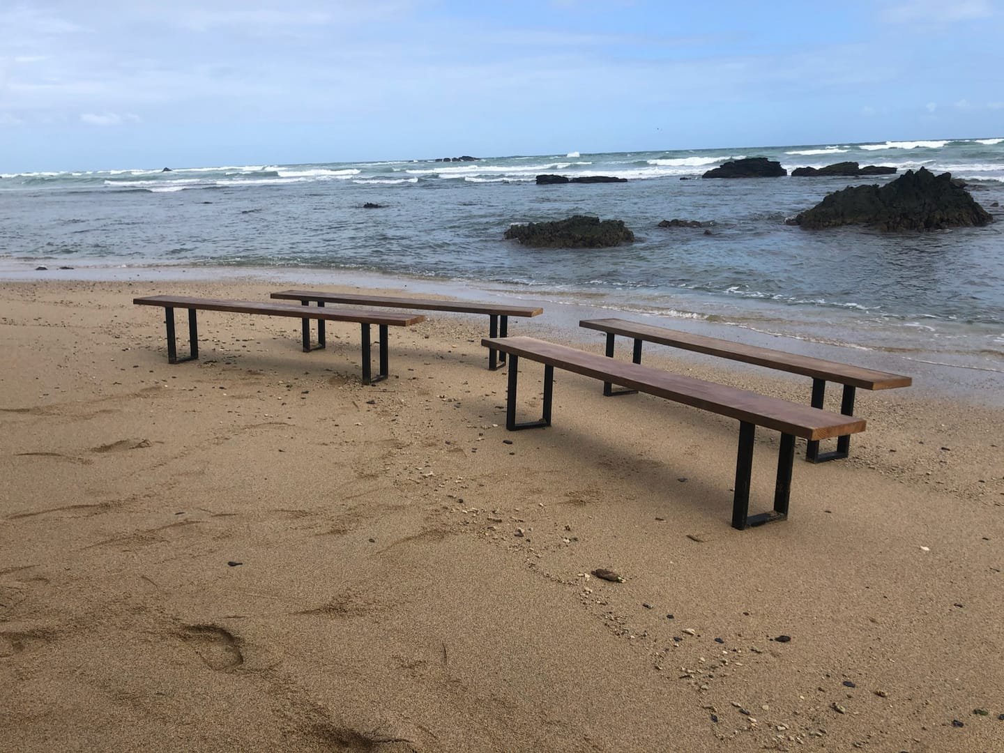 French Farm Bench: A handcrafted bench with a seat of salvaged timber and black metal legs, with the wood grain visible from every side.
