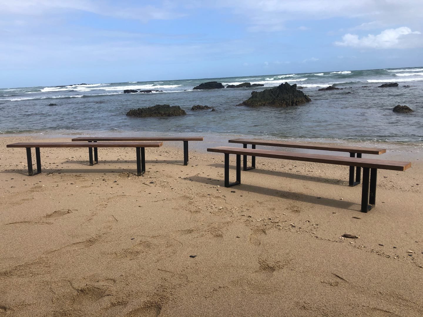 French Farm Bench: A handcrafted bench with a seat of salvaged timber and black metal legs, with the wood grain visible from every side.