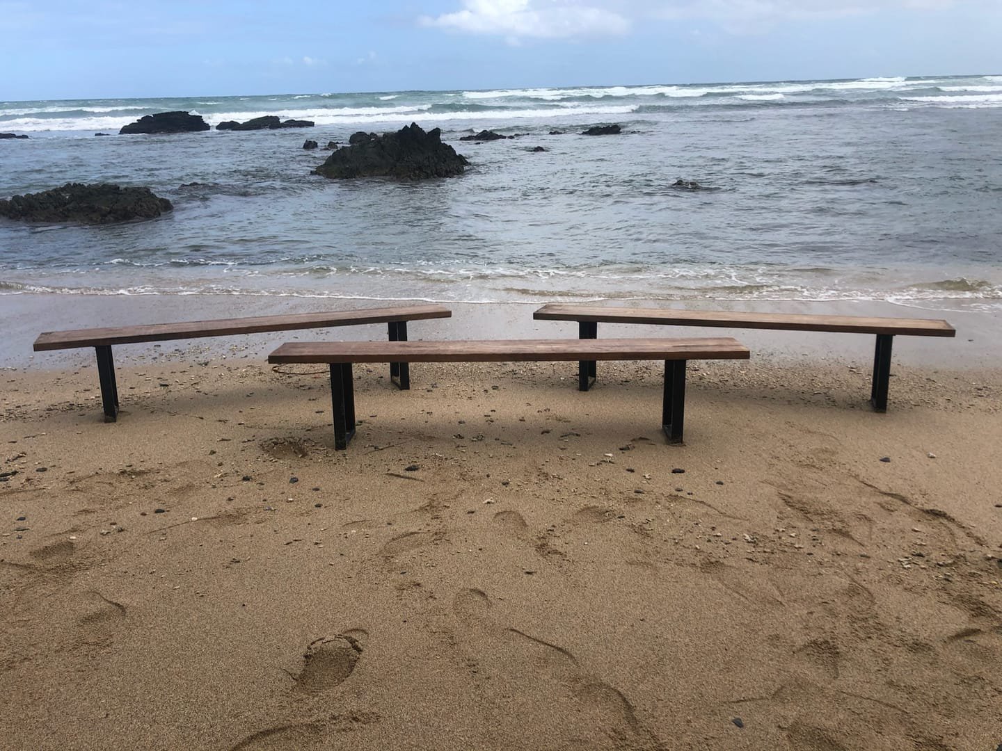 French Farm Bench: A handcrafted bench with a seat of salvaged timber and black metal legs, with the wood grain visible from every side.