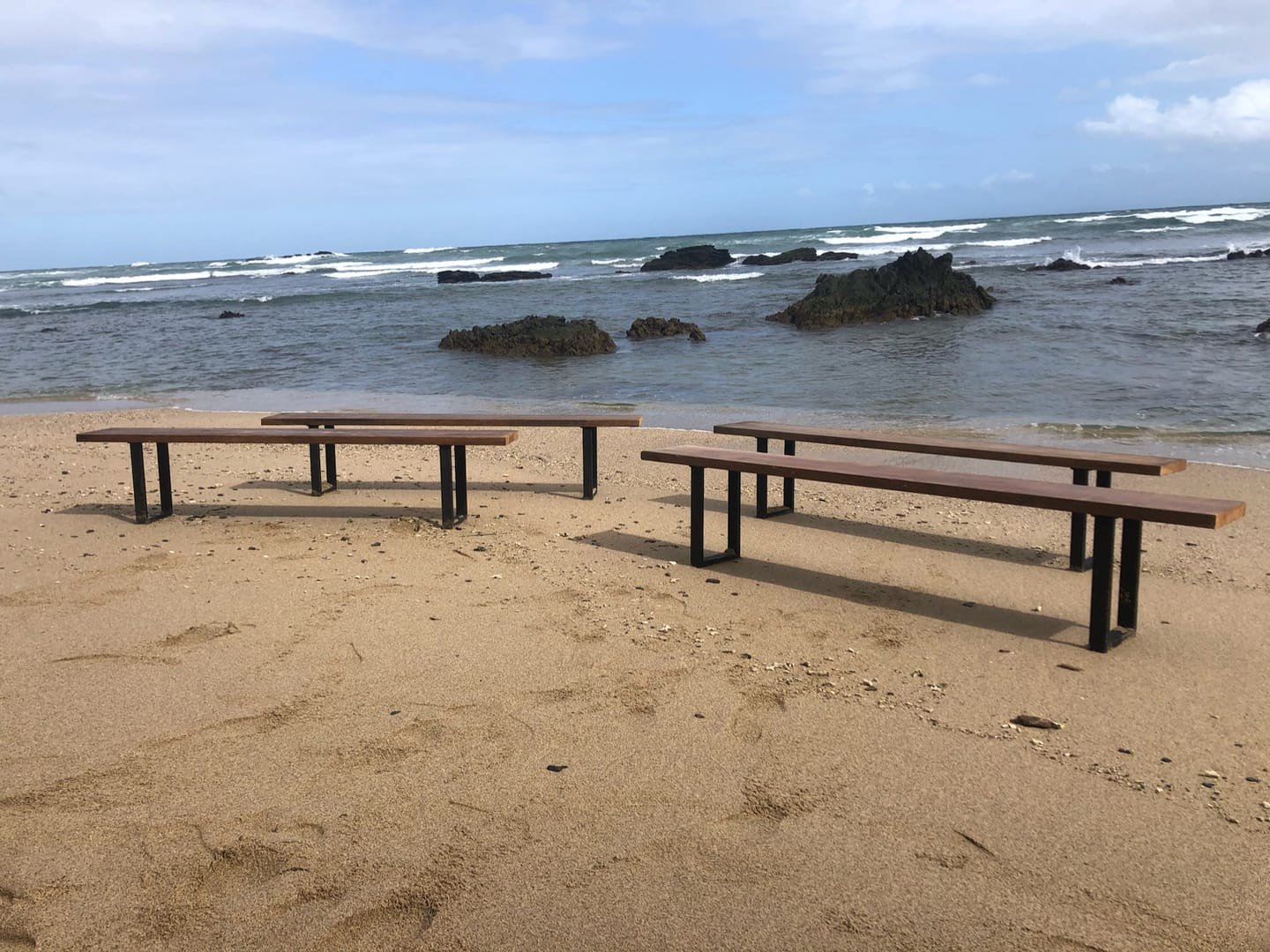 French Farm Bench: A handcrafted bench with a seat of salvaged timber and black metal legs, with the wood grain visible from every side.