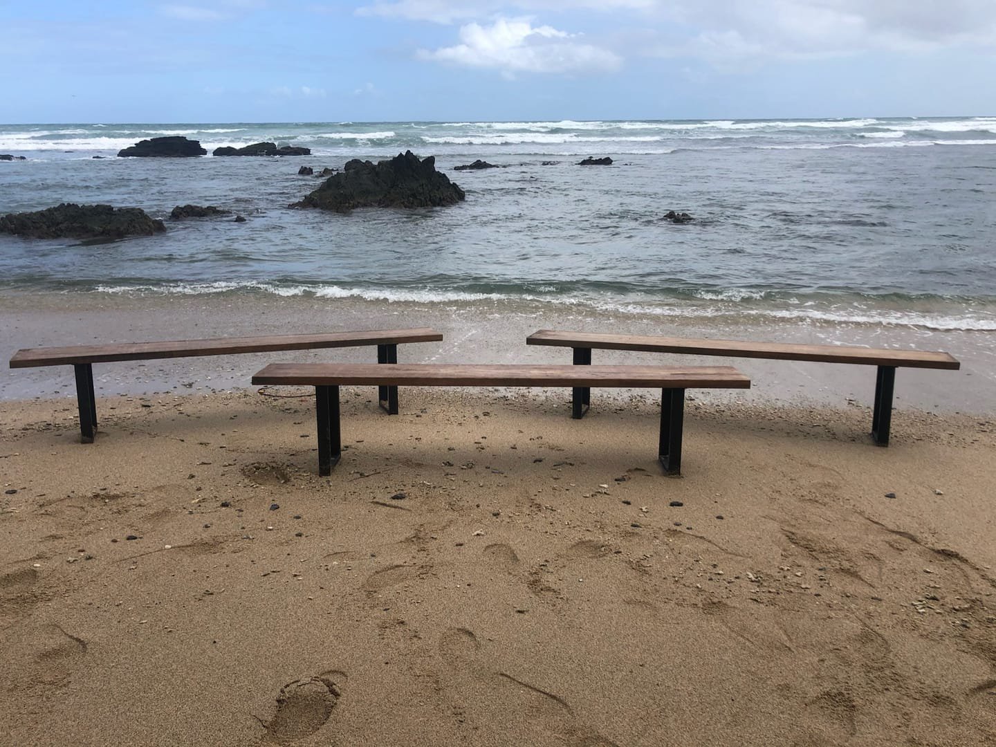 French Farm Bench: A handcrafted bench with a seat of salvaged timber and black metal legs, with the wood grain visible from every side.