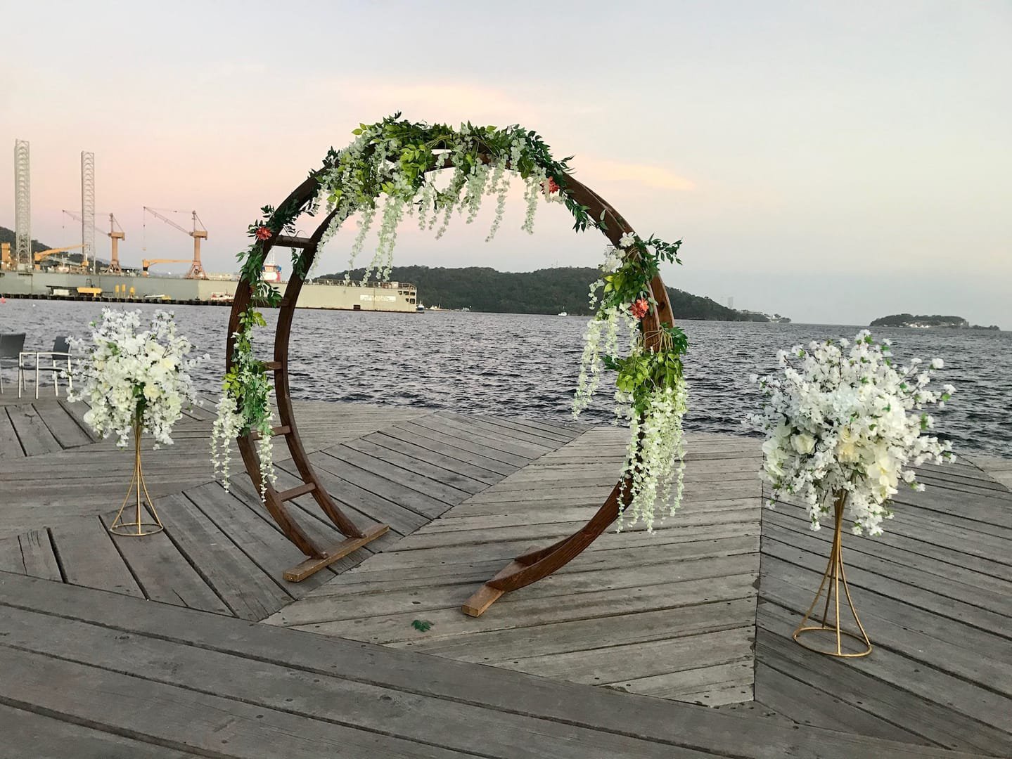 Oval Arch: A modern wooden circular arch used as a wedding ceremony arch, an entryway to the aisle or event, or a backdrop behind a pallet bar or sweetheart
