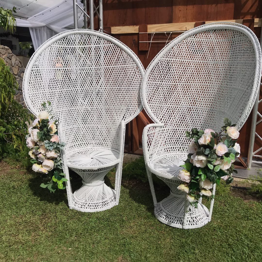 Peacock Chair: A white wicker peacock chair with a high, arched back that gives it a throne-like look, available plain white or with gold trim on the backrest.