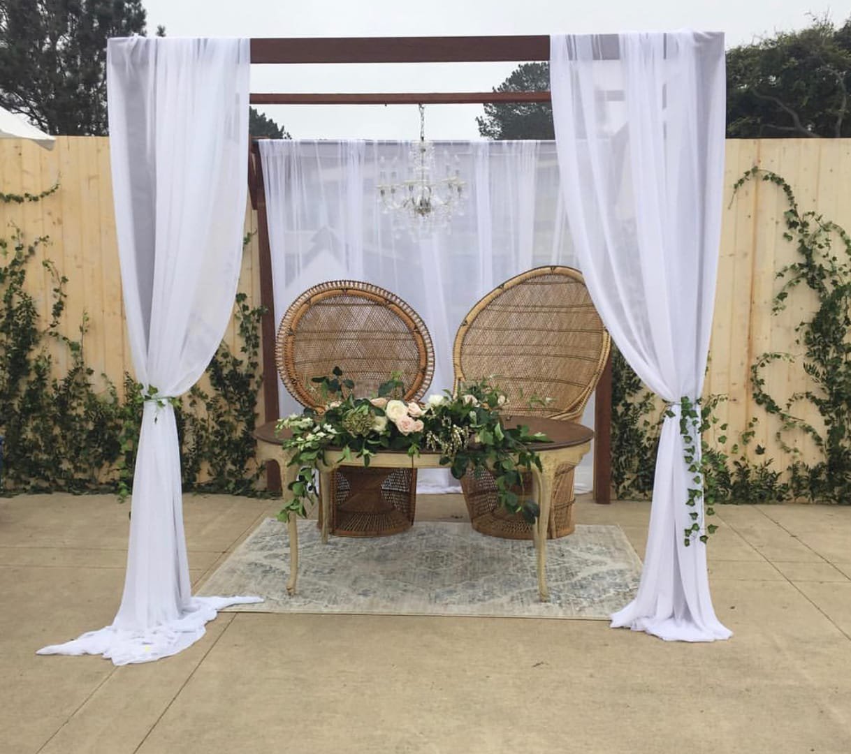 Peacock Chair: A white wicker peacock chair with a high, arched back that gives it a throne-like look, available plain white or with gold trim on the backrest.