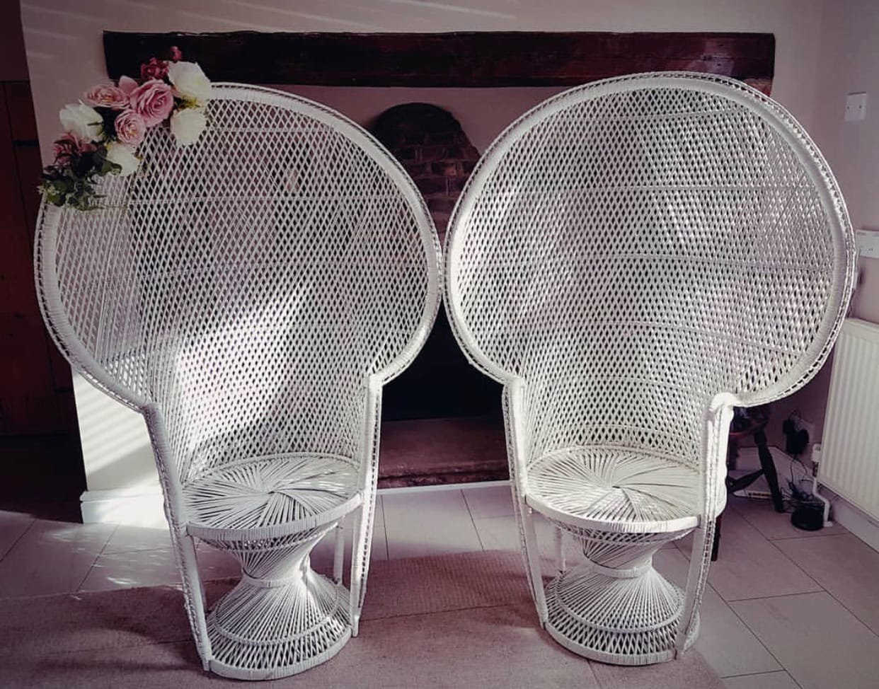 Peacock Chair: A white wicker peacock chair with a high, arched back that gives it a throne-like look, available plain white or with gold trim on the backrest.
